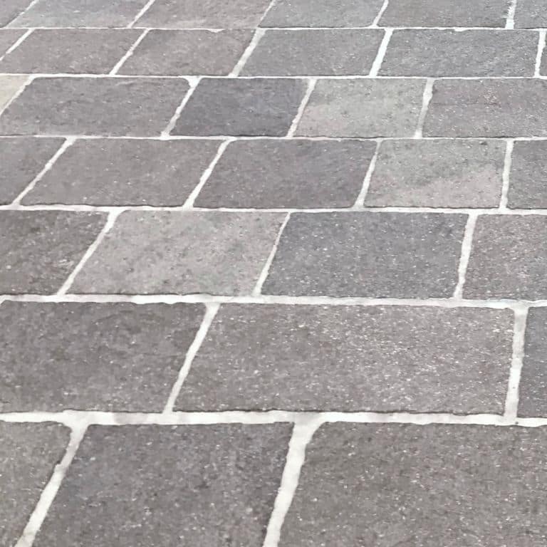 Close-up image for Porphyry Natural Surface - Mixed Gray Pavers. Dominant colors shown are gray and purple; with a beige secondary. The color mix creates a cool feeling. Regular, speckled and cloudy color patterns.