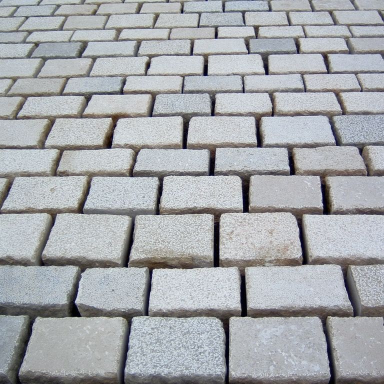 Application image for Limestone - Mountain Hard - Cobblestones Mix. The image shows this product being used in a patio pavers application. Dominant colors shown are gray and tan.