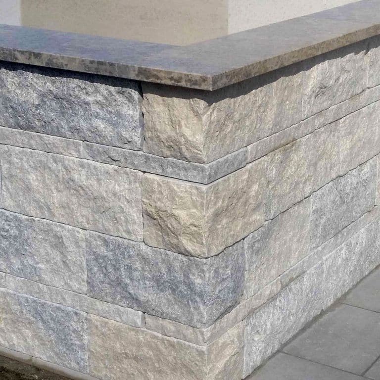 Feature image for Mountain Hard Limestone Mix - Wall Veneer. The image shows this product being used in a full bed veneer application. The dominant color shown is gray; with beige, blue, purple, white and cream secondaries. Exhibits "movement". Blotched, swirled and cloudy color patterns.