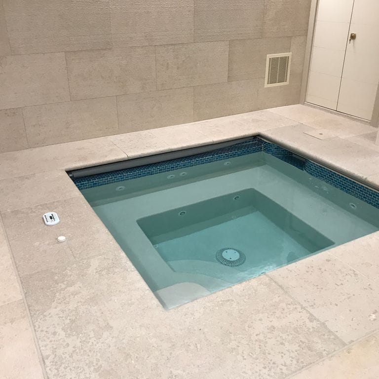 Application image for Mountain Hard Beige Limestone - Pool Deck. The image shows this product being used for pool coping and pool deck pavers. Dominant colors shown are beige and tan; with gray and cream secondaries. Exhibits "movement" and the color mix creates a warm feeling. Regular and cloudy color patterns.
