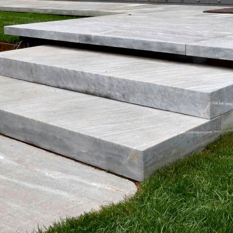 Close-up image for Granite- Mystic Mountain- Steps. The surface finish shown is flamed. The dominant color shown is gray; with beige, pink, purple and white secondaries. Exhibits "movement" and the color mix creates a cool feeling. Linear and streaked color patterns.