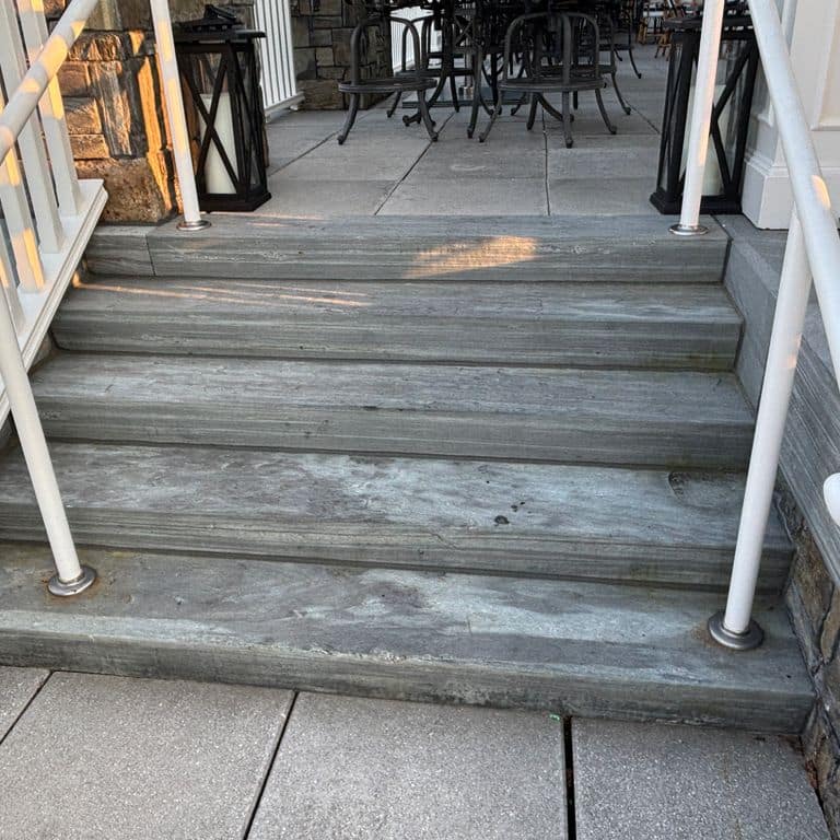 Application image for Mystic Mountian Granite - Sawn Steps. The image shows this product being used in a monolithic steps application. The surface finish shown is flamed. The dominant color shown is gray. The color mix creates a warm feeling.