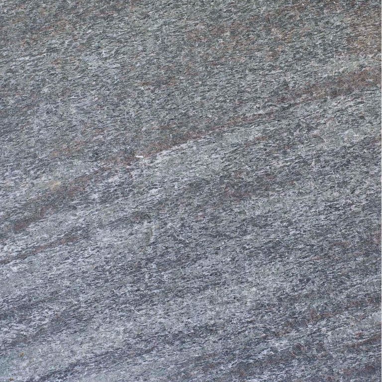 Swatch image cropped for Mystic Mountain Countertops. The surface finish shown is flamed. Dominant colors shown are blue and gray; with brown, green, purple and white secondaries. Exhibits "movement" and the color mix creates a cool feeling. Fine speckled, linear and streaked color patterns.