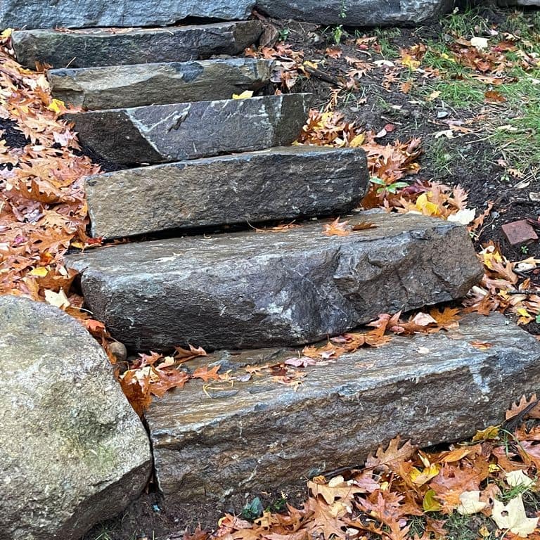 Application image for Mystic Mountain Natural - Steps &amp; Landings. The image shows this product being used in a monolithic steps application. The surface finish shown is natural cleft. Dominant colors shown are blue and gray; with brown, green and purple secondaries. The color mix creates a cool feeling.