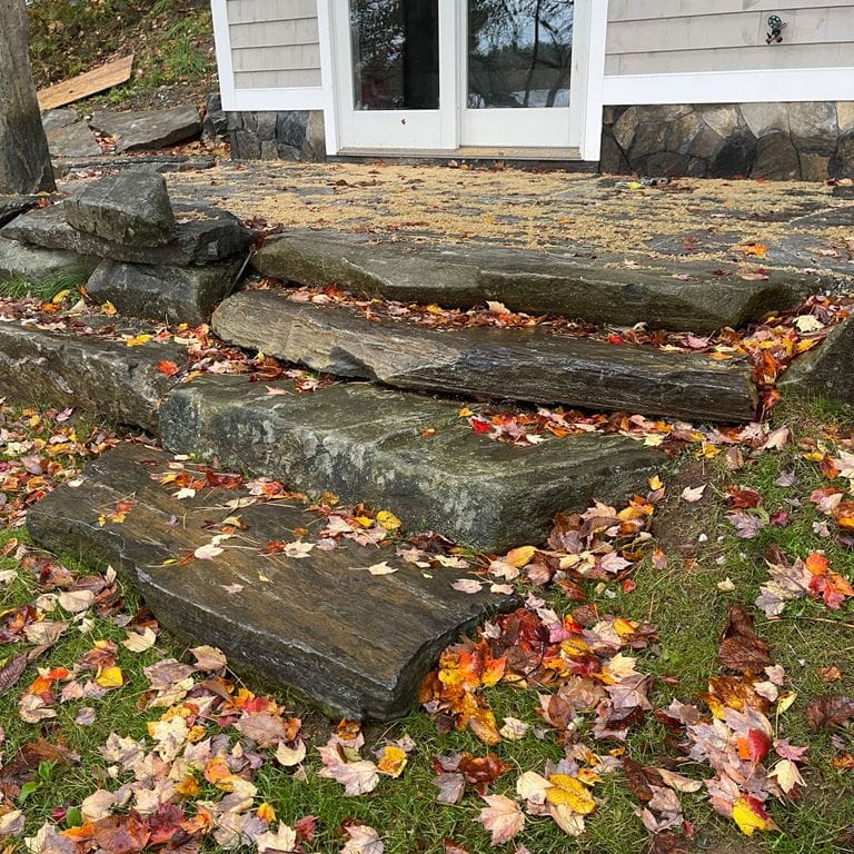 Application image for Mystic Mountain Natural - Steps &amp; Landings. The image shows this product being used for landings and monolithic steps. The surface finish shown is a combination of natural cleft and natural. Dominant colors shown are brown and gray; with green and tan secondaries.