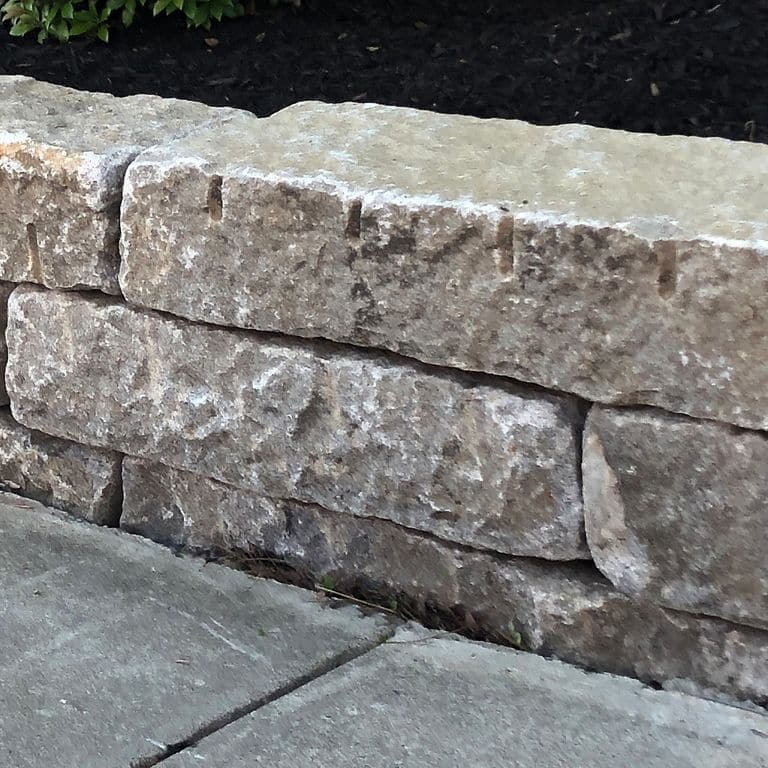 Close-up image for Reclaimed Granite Curbstone - Junior Wallstone. The surface finishes shown are split-face, weathered and worn. The dominant color shown is gray; with beige, brown, green, purple and white secondaries. Exhibits "movement" and the color mix creates a cool feeling. Random, blotched, swirled and cloudy color patterns.