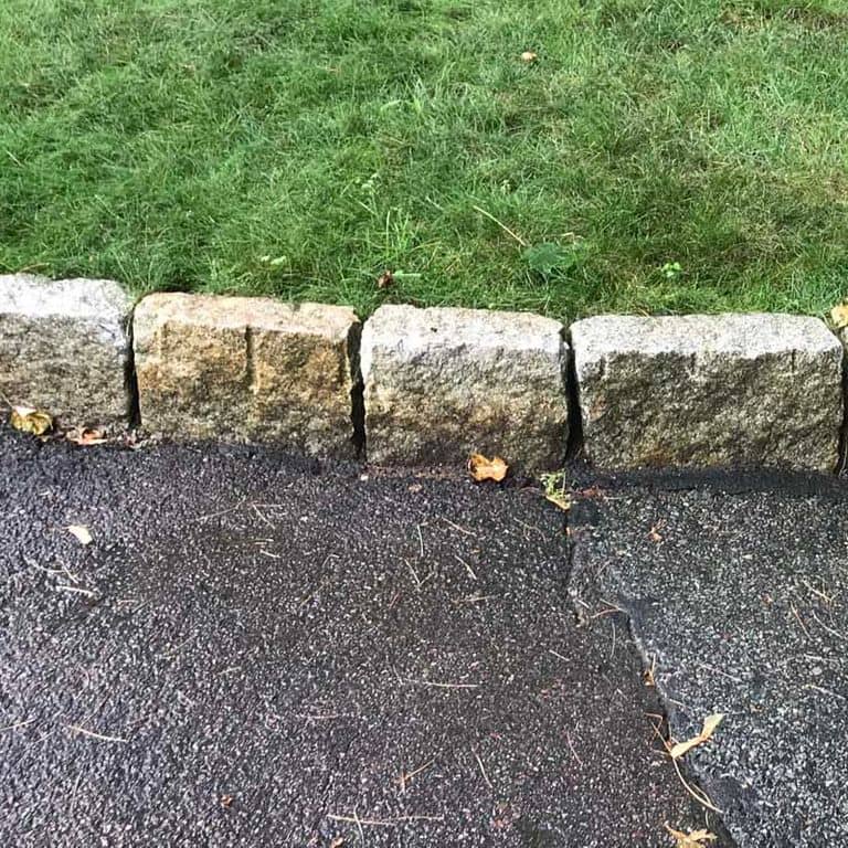 Close-up image for Reclaimed New England Granite Cobblestones - Super Jumbo Edging. The surface finishes shown are split-face, weathered and worn. The dominant color shown is gray; with beige, brown, green, orange/rust, white and tan secondaries. Exhibits "movement". Random, speckled and blotched color patterns.
