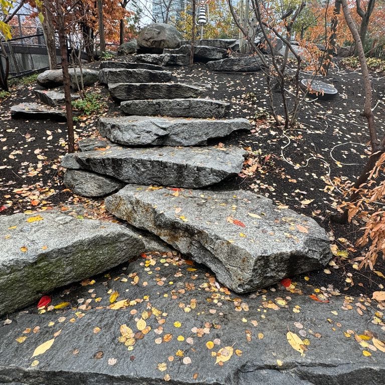 Application image for Granite - Reclaimed New England Quarry Tailings - Seating. The image shows this product being used for garden accents and seating &amp; benches. The dominant color shown is gray.