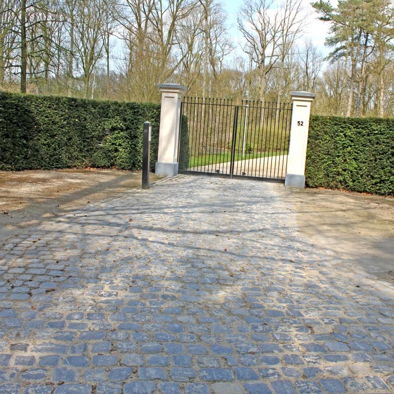 Application image for Reclaimed Belgian Bluestone Cobblestones - Worn Surface. The image shows this product being used in a driveway pavers application. The surface finish shown is . Dominant colors shown are blue and gray. The color mix creates a warm feeling.