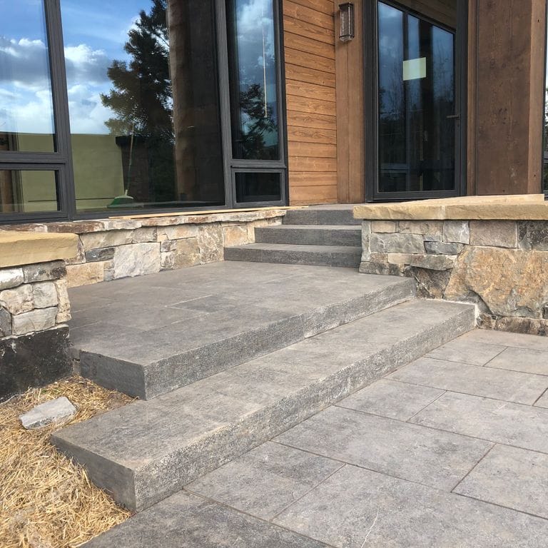 Feature image for Highland Limestone - Steps. The image shows this product being used in a monolithic steps application. The surface finish shown is flamed. The dominant color shown is gray. Regular color pattern.