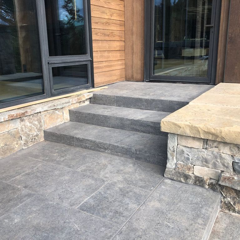 Application image for Highland Limestone - Steps. The image shows this product being used in a monolithic steps application. The surface finish shown is flamed. The dominant color shown is gray. The color mix creates a warm feeling.