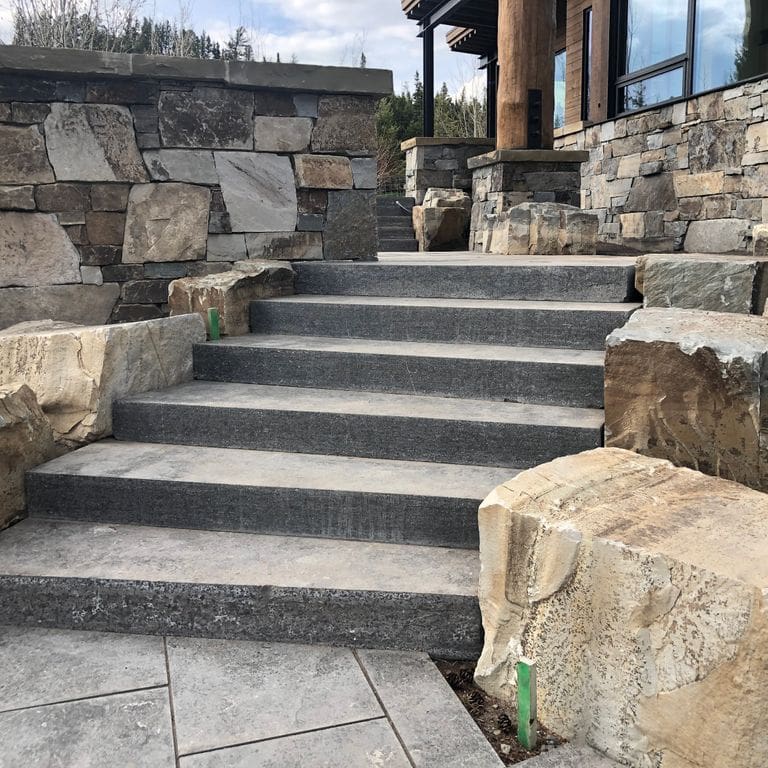 Application image for Highland Limestone - Steps. The image shows this product being used in a monolithic steps application. The surface finish shown is flamed. The dominant color shown is gray. The color mix creates a cool feeling.