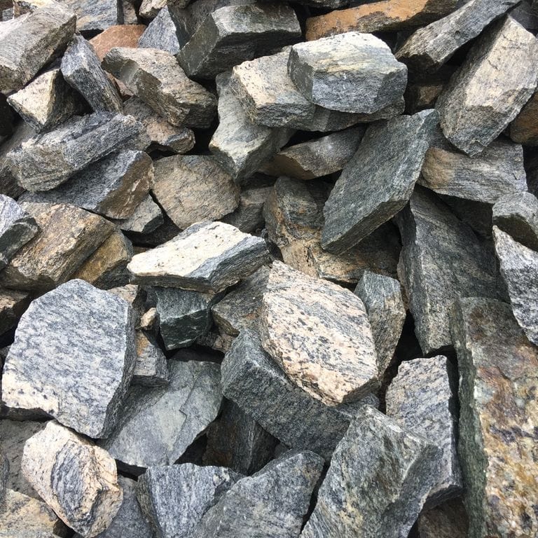 Close-up image for Hudson Granite - Full Bed Veneer. The surface finish shown is natural cleft. The dominant color shown is gray; with beige, brown, green, orange/rust, white, tan and cream secondaries. Exhibits "movement". Speckled, blotched and streaked color patterns.