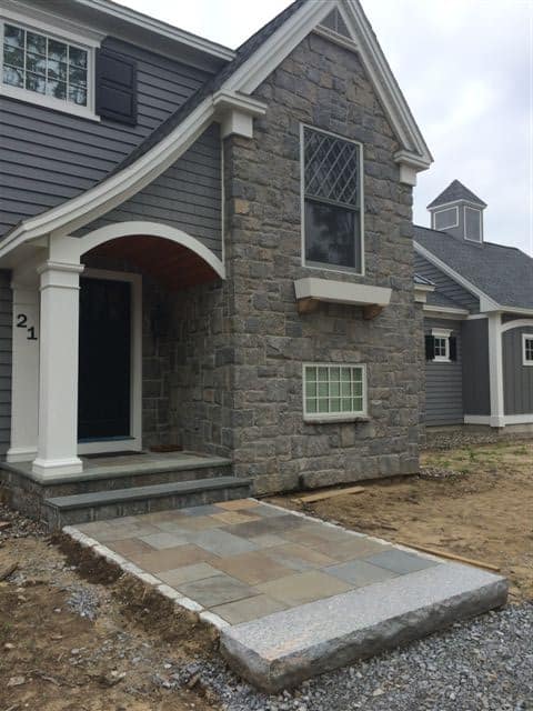 Application image for Hawthorne Granite - Veneer. The image shows this product being used for full bed veneer and thin veneer. The surface finish shown is split-face. Dominant colors shown are brown and gray; with blue and tan secondaries. The color mix creates a warm feeling.