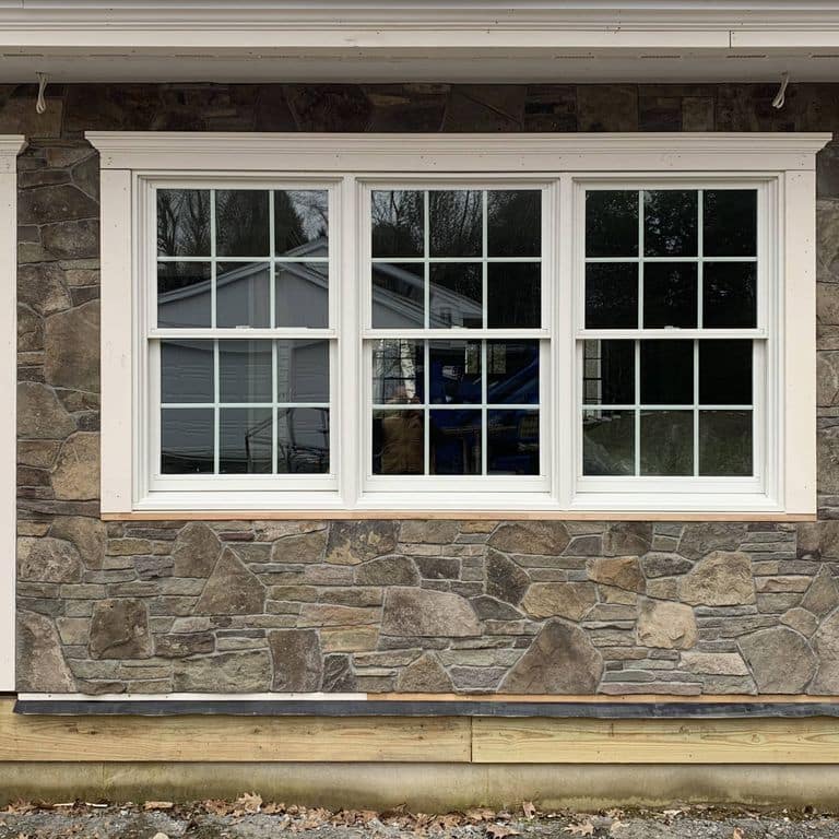 Feature image for Old Yankee Fieldstone - Veneer. The image shows this product being used in a full bed veneer application. Dominant colors shown are brown and gray; with beige, purple, tan and cream secondaries. Exhibits "movement" and the color mix creates a warm feeling. Speckled, blotched and cloudy color patterns.