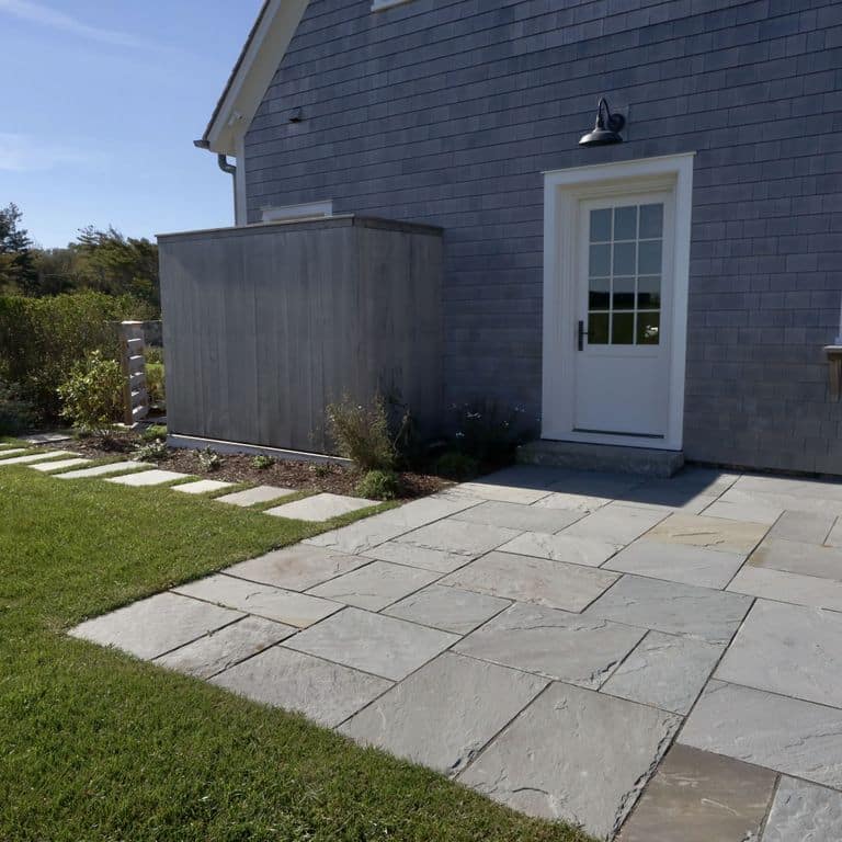 Application image for Bluestone Natural Cleft Blue/Gray - Dimensional Cut Pavers. The image shows this product being used in a patio pavers application. The surface finish shown is natural cleft. The dominant color shown is gray. The color mix creates a cool feeling.