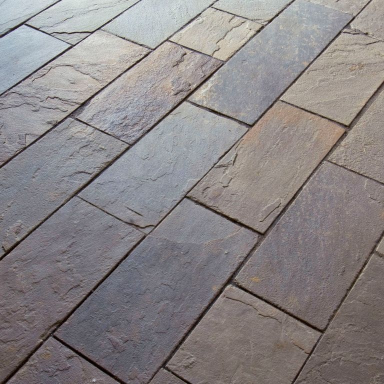 Close-up image for Bluestone Natural Cleft Full Color Mix - Interior Flooring. The surface finish shown is natural cleft. Dominant colors shown are blue, brown, green and purple; with an orange/rust secondary. Exhibits "movement". Random, blotched, swirled and cloudy color patterns.