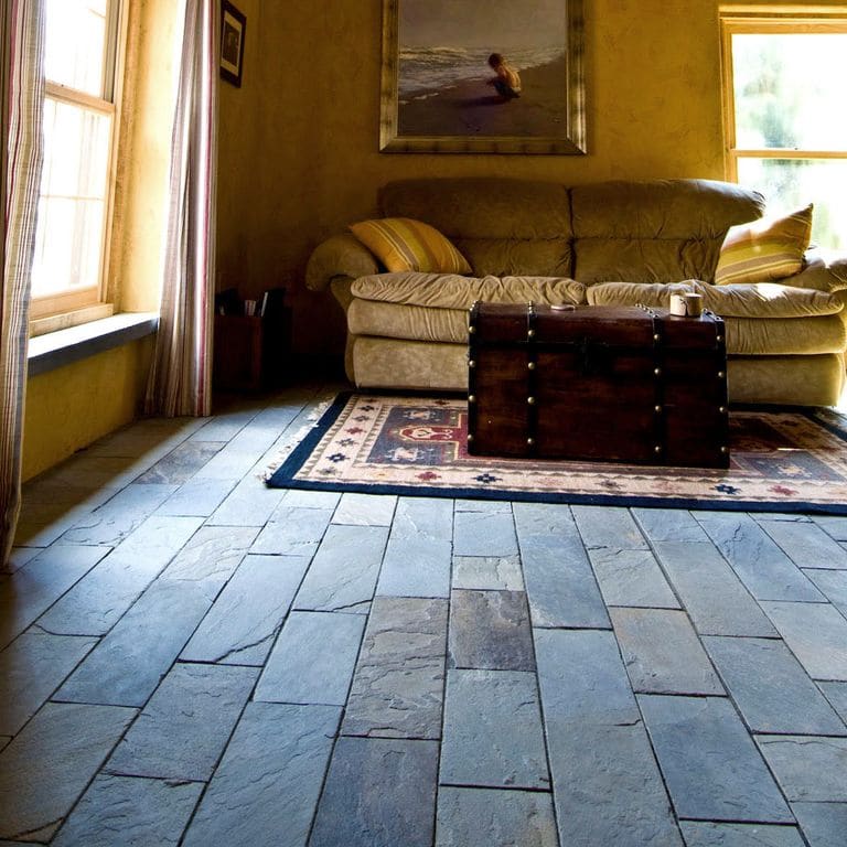 Feature image for Bluestone Natural Cleft Full Color Mix - Interior Flooring. The image shows this product being used in an interior floor application. Dominant colors shown are blue, brown, gray and purple; with black, orange/rust and tan secondaries. Exhibits "movement". Random color pattern.