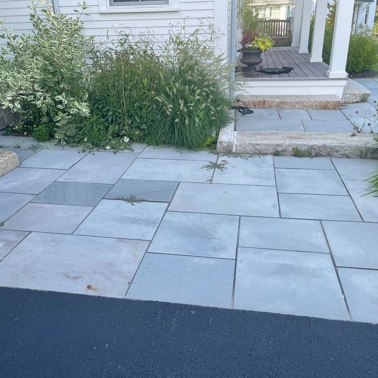 Application image for Bluestone Flamed Surface Blue/Gray - Dimensional Cut Pavers. The image shows this product being used for path pavers and patio pavers. The surface finish shown is flamed. Dominant colors shown are blue and gray. The color mix creates a cool feeling. Solid color pattern.