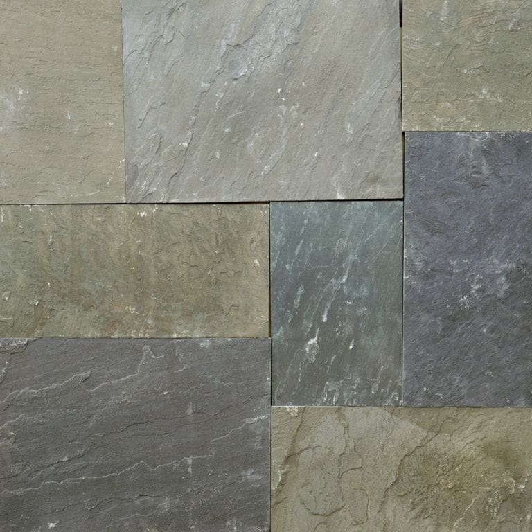 Best close-up image for Bluestone - Clear Color Mix- Natural Cleft - Dimensional Cut Pavers. The image shows this product being used in a patio pavers application. The surface finish shown is natural cleft. Dominant colors shown are green and gray; with brown and purple secondaries. Exhibits "movement". Streaked, blotched and random color patterns.