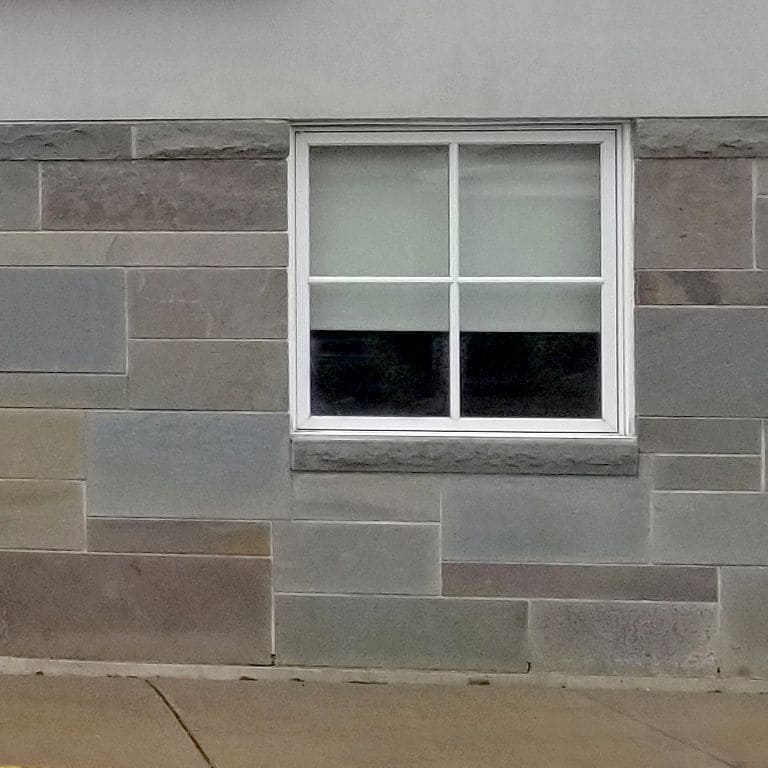 Close-up image for Bluestone Natural Cleft Full Color Mix - Full Bed Veneer. The surface finish shown is natural cleft. Dominant colors shown are green and gray; with brown and purple secondaries. Exhibits "movement". Random color pattern.