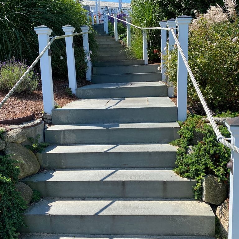 Feature image for Bluestone Flamed Surface Blue/Gray - Monolithic Steps. The image shows this product being used in a monolithic steps application. The dominant color shown is gray. The color mix creates a cool feeling. Solid color pattern.