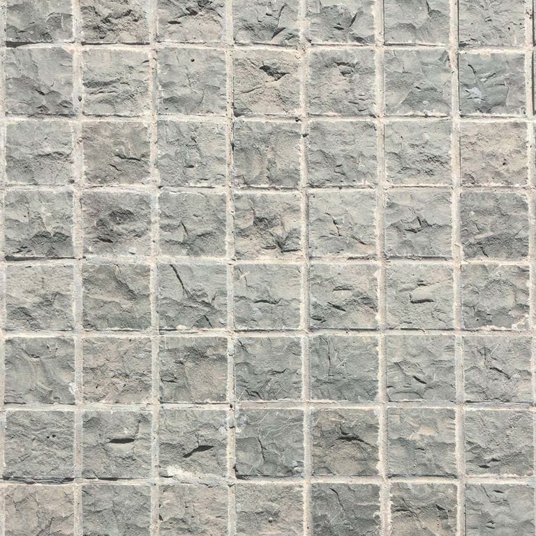 Close-up image for Ankar Gray Basalt - Cobblestones. The surface finish shown is split-face with flat plane. Dominant colors shown are beige and gray; with pink, white, tan and cream secondaries. Exhibits "movement" and the color mix creates a cool feeling. Regular color pattern.