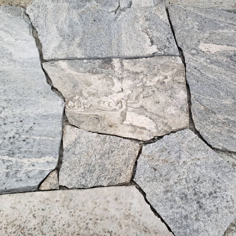 Close-up image for Liberty Hill Granite - Monolithic Steps. The surface finish shown is split-face. The dominant color shown is gray; with beige, pink, white and cream secondaries. Exhibits "movement". Random, marbled, speckled, swirled and streaked color patterns.