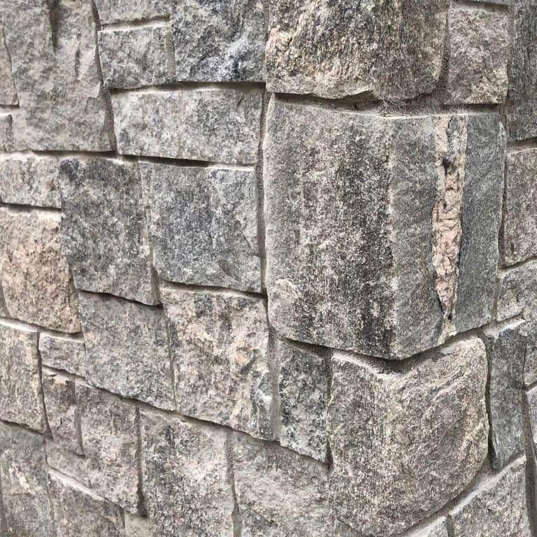 Close-up image for Granite - Liberty Hill - Veneer. The surface finish shown is split-face with flat plane. The dominant color shown is gray; with beige, green, pink, purple, white, tan and cream secondaries. Exhibits "movement". Random, speckled, linear, swirled and streaked color patterns.