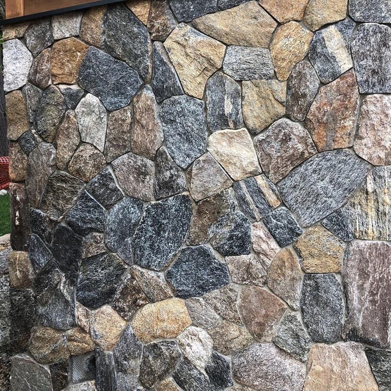 Close-up image for Fieldstone - Old New England Wall - Wall Veneer. The dominant color shown is gray; with beige, black, blue, brown, green, orange/rust, purple, white, tan and cream secondaries. Exhibits "movement" and the color mix creates a warm feeling. Random, speckled and streaked color patterns.