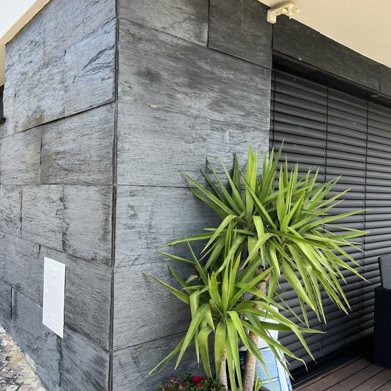 Feature image for Black Schist - Cut to Size Veneer. The image shows this product being used in a full bed veneer application. The surface finish shown is natural cleft. Dominant colors shown are black and gray. The color mix creates a cool feeling.