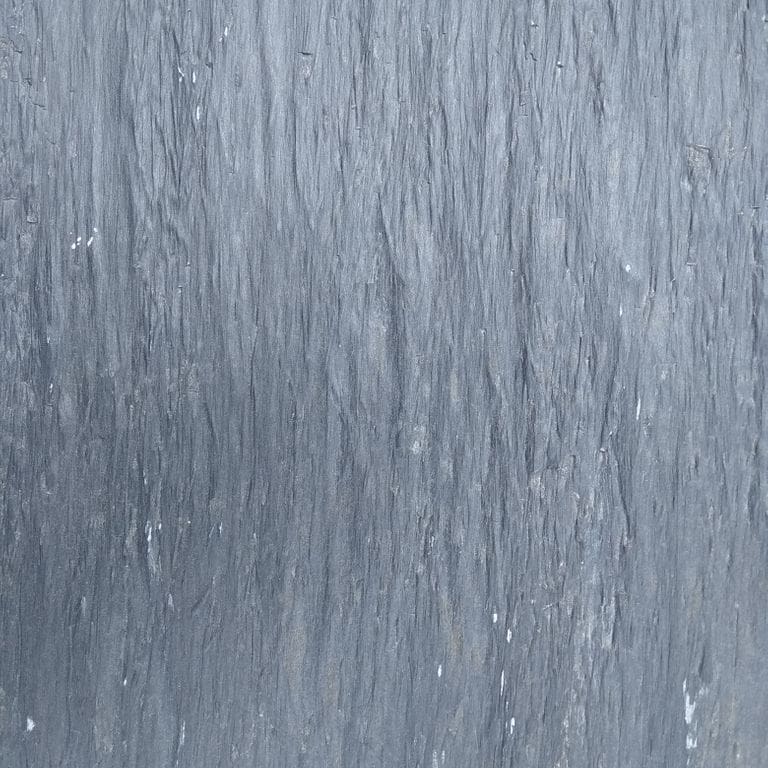 Swatch image cropped for Black Shale - Pavers. The surface finish shown is natural. Dominant colors shown are blue and gray. Exhibits "movement" and the color mix creates a cool feeling. Regular color pattern.