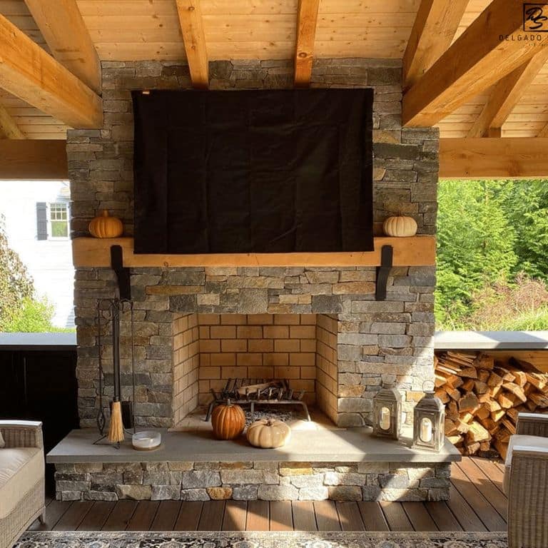 Feature image for Granite - Spruce Mountain- Veneer. The image shows this product being used for fireplace surround, full bed veneer and thin veneer. The surface finish shown is split-face. Dominant colors shown are gray, orange/rust and tan; with green, orange/rust, purple and tan secondaries. Exhibits "movement" and the color mix creates a warm feeling. Streaked, speckled, blotched and random color patterns.