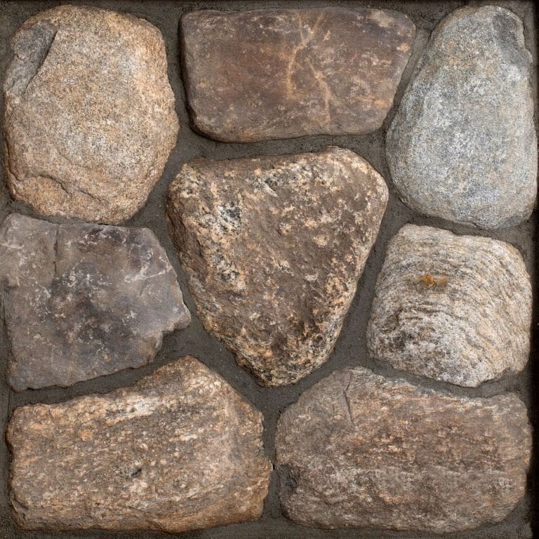 Best close-up image for Old New England Fieldstone Rounds - Thin Veneer. The surface finish shown is natural. Dominant colors shown are brown, gray and tan; with orange/rust, purple and tan secondaries. Exhibits "movement" and the color mix creates a warm feeling. Streaked, speckled and blotched color patterns.