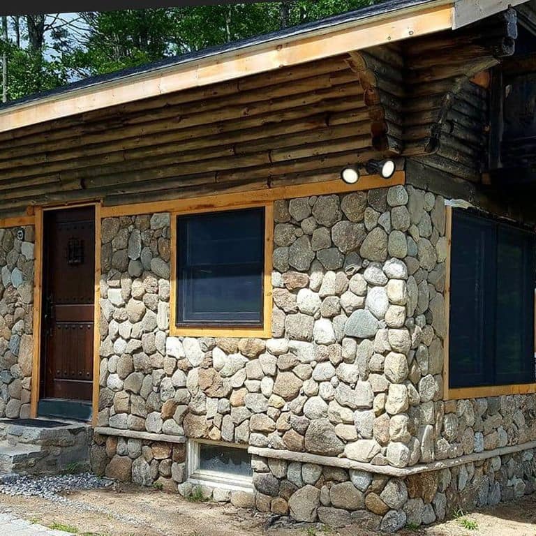 Feature image for Fieldstone - Old New England Rounds - Thin Veneer. The image shows this product being used in a thin veneer application. Dominant colors shown are beige, gray, white and cream; with a brown secondary. Exhibits "movement" and the color mix creates a warm feeling. Regular and speckled color patterns.