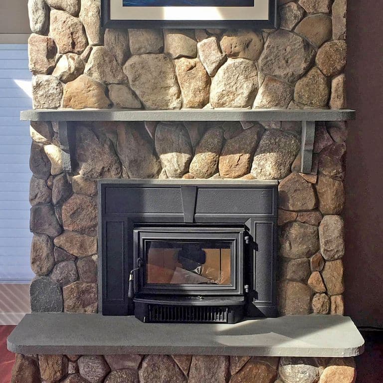 Application image for Fieldstone - Old New England Rounds - Thin Veneer. The image shows this product being used for fireplace surround and thin veneer. The surface finish shown is natural. Dominant colors shown are gray and tan. The color mix creates a warm feeling. Regular, speckled and random color patterns.