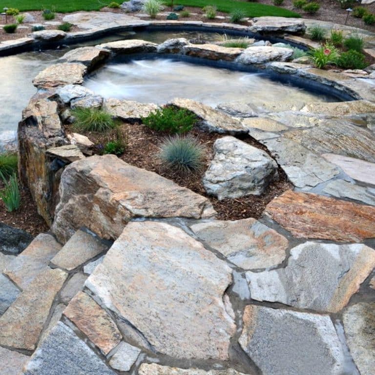 Close-up image for Granite- Colonial Tan - Pavers. The surface finishes shown are natural and split-face. The dominant color shown is gray; with beige, blue, brown, orange/rust, pink, purple, white and tan secondaries. Exhibits "movement". Random, speckled, blotched and streaked color patterns.