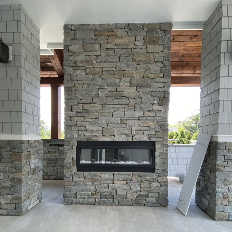 Feature image for Colonial Wall Granite - Wall Veneer. The image shows this product being used for full bed veneer and thin veneer. Dominant colors shown are green and gray; with beige, brown and purple secondaries. Exhibits "movement". Regular color pattern.