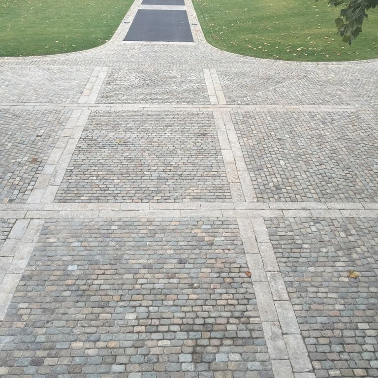 The image shows this product being used in a driveway pavers application.