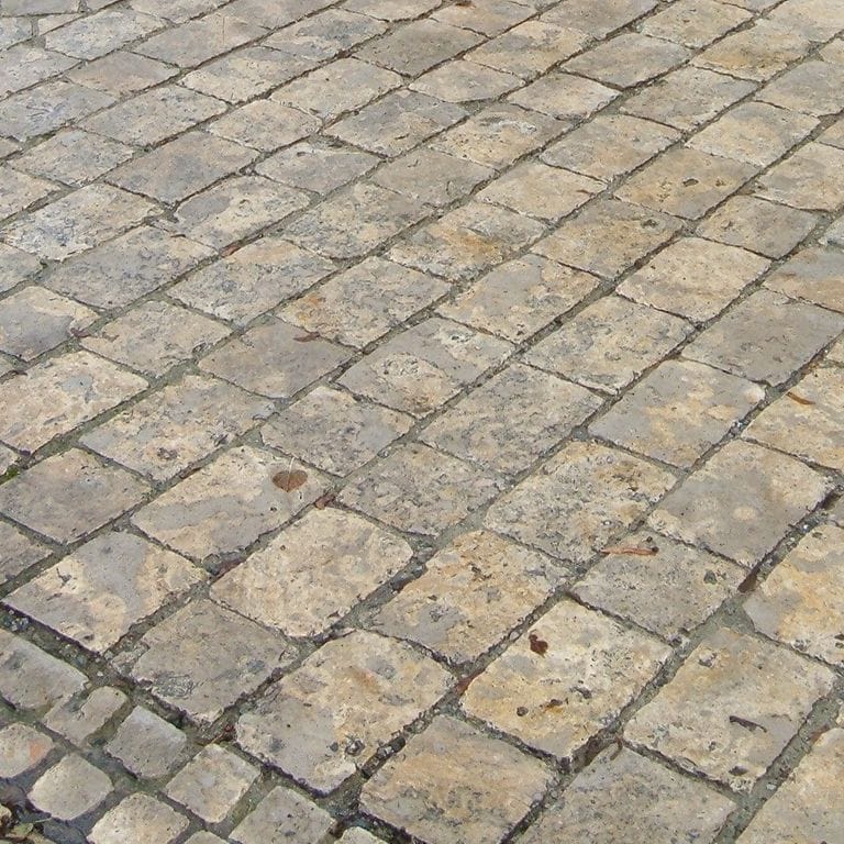 Close-up image for Bavarian Dolomite - Gray - Cobblestones. The surface finishes shown are antiqued and tumbled. The dominant color shown is gray; with beige, brown and orange/rust secondaries. Exhibits "movement" and the color mix creates a warm feeling. Regular, blotched and cloudy color patterns. Contains mineral inclusions.
