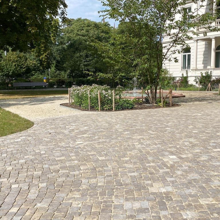 Application image for Bavarian Dolomite Gray Limestone - Cobblestones. The image shows this product being used in a public area application. Dominant colors shown are beige, gray and tan. The color mix creates a warm feeling.