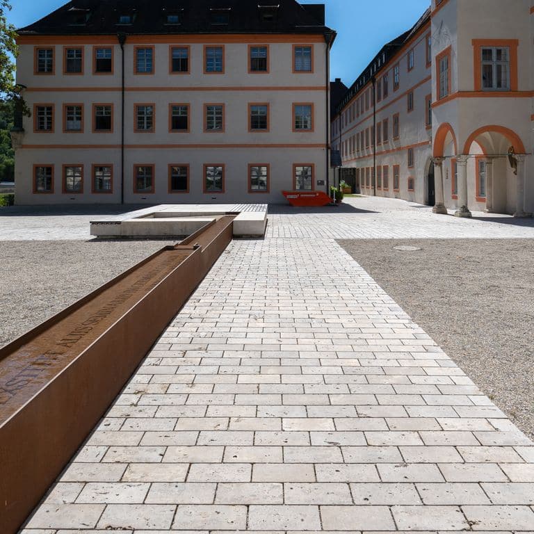 Application image for Bavarian Dolomite Gray Limestone - Cobblestones. The image shows this product being used in a public area application. Dominant colors shown are gray and tan. The color mix creates a warm feeling.
