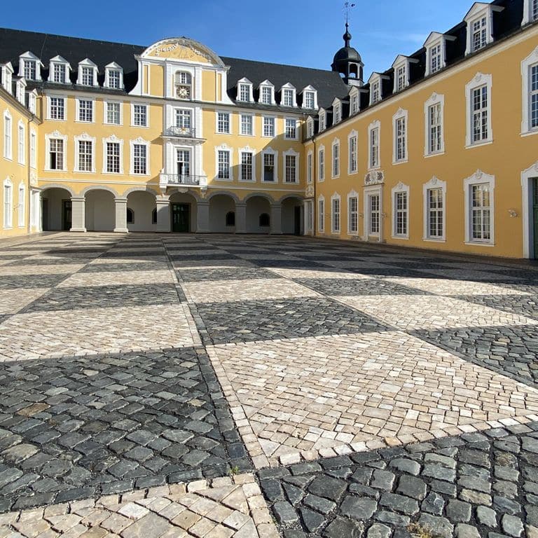 Application image for Bavarian Dolomite Gray Limestone - Cobblestones. The image shows this product being used in a public area application. Dominant colors shown are beige, gray and tan. The color mix creates a warm feeling.
