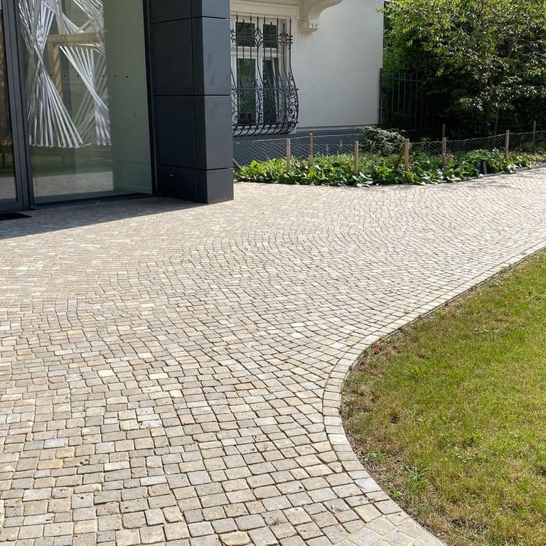 Application image for Bavarian Dolomite Gray Limestone - Cobblestones. The image shows this product being used for path pavers and public area. Dominant colors shown are beige, gray and tan. The color mix creates a warm feeling.