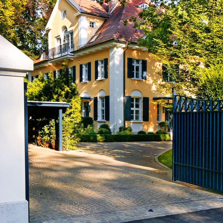 Application image for Bavarian Dolomite Gray Limestone - Cobblestones. The image shows this product being used in a driveway pavers application. Dominant colors shown are gray and tan. The color mix creates a warm feeling.