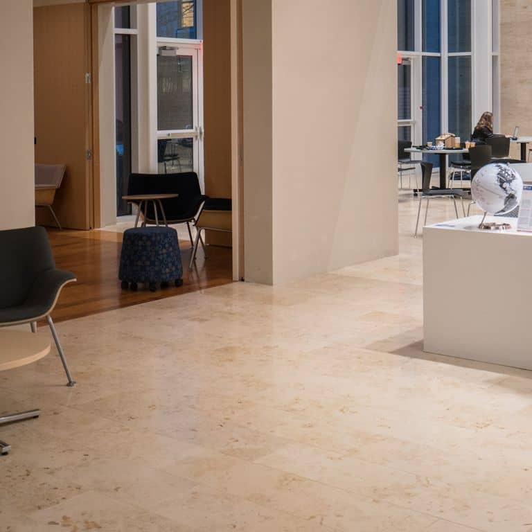 Close-up image for Bavarian Travertine - Beige - Interior Floor. The surface finish shown is honed. Dominant colors shown are beige, brown and tan; with an orange/rust secondary. Exhibits "movement" and the color mix creates a warm feeling. Swirled and cloudy color patterns. Contains mineral inclusions.