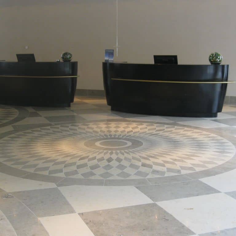 Application image for Bavarian Gray Limestone - Interior Floor. The image shows this product being used in an interior floor application. The dominant color shown is gray; with beige, white and tan secondaries. Exhibits "movement" and the color mix creates a cool feeling. Swirled, blotched and cloudy color patterns. Contains mineral inclusions.