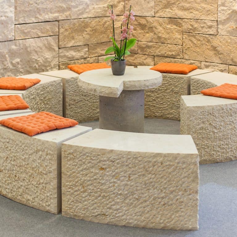 Feature image for Bavarian Limestone Gala - Beige - Benches &amp; Seating. The image shows this product being used in a seating &amp; benches application. Dominant colors shown are beige and tan; with brown, orange/rust and cream secondaries. The color mix creates a warm feeling. Regular and coarse speckled color patterns. Contains mineral inclusions.