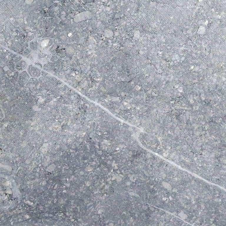 Swatch image cropped for Reclaimed Belgian Bluestone Cobblestones - Flat Surface. The surface finish shown is sawn. Dominant colors shown are blue and gray; with a white secondary. Exhibits "movement" and the color mix creates a cool feeling. Coarse speckled, blotched, veined and cloudy color patterns.