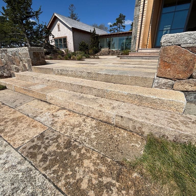 Application image for Reclaimed Footworn Granite - Monolithic Steps. The image shows this product being used in a monolithic steps application. The surface finish shown is . The dominant color shown is tan. The color mix creates a warm feeling.
